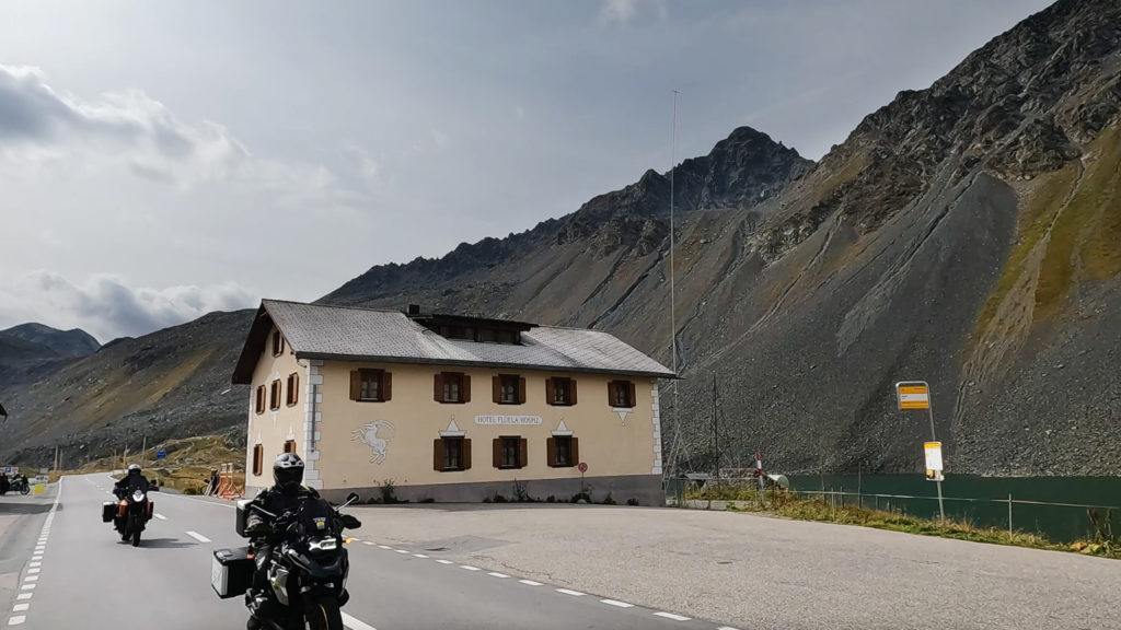 Passhöhe des Flüelapasses auf 2383Metern. zu sehen ist das Ospizio Flüela und das gesamte Bermassiv. Zu sehen sind ebenfalls Motorradfahrer, die ein Motorrad durch die Alpen manchen – genannt: Alpen-Marathon. Die Tour ist einzigartig und wird undter dem Motto "7/6/50" in sieben Tagen durch 6 Länder über 50 Pässe angeboten. Die Motorräder sind Reiseenduros von BMW und KTM